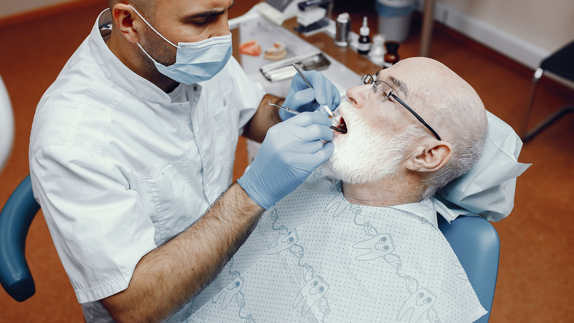 an old man filling his information to register as a new patient with our dentist near me