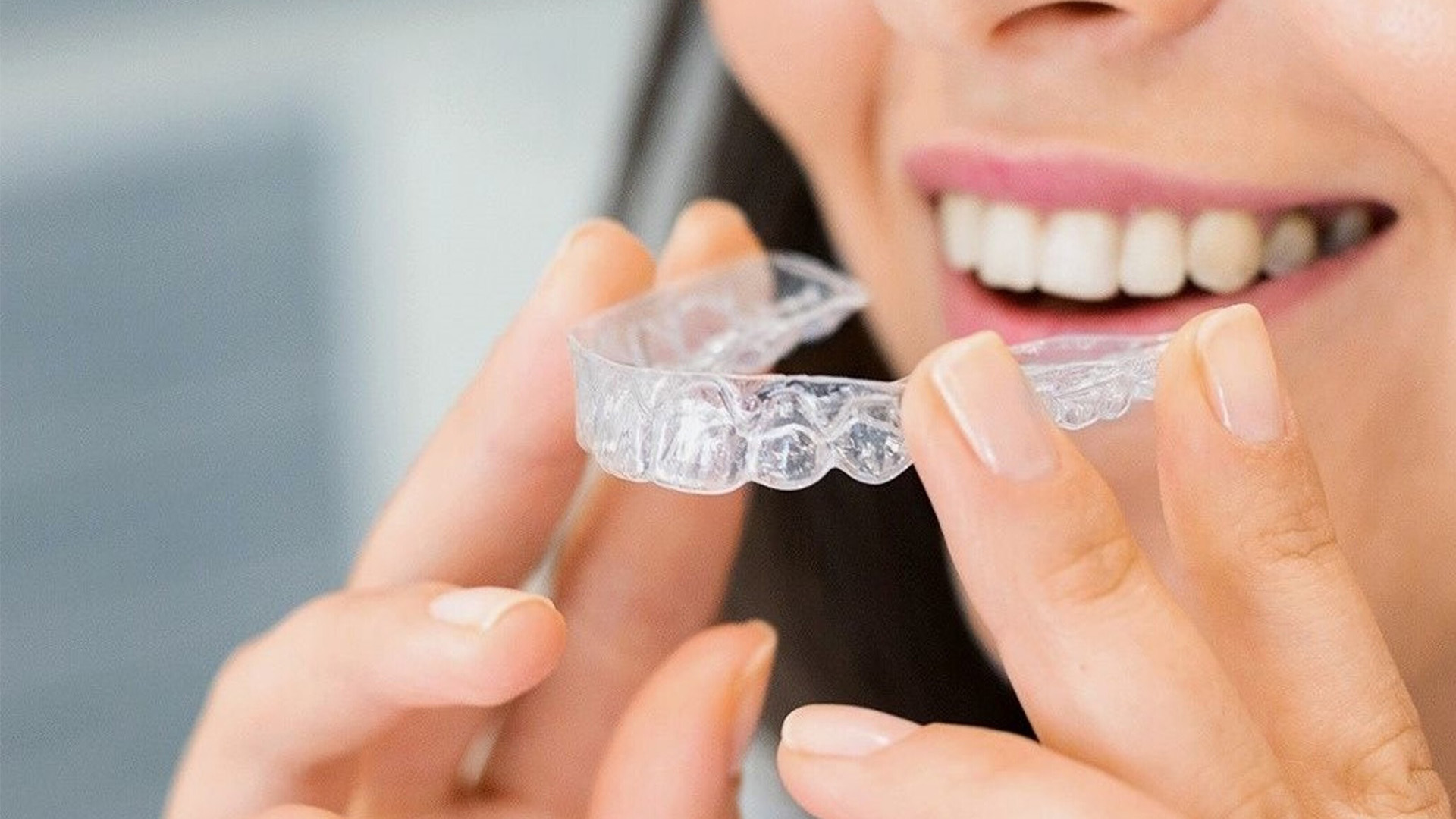 a young girl applying clear braces after consulting with our invisalign dentist
