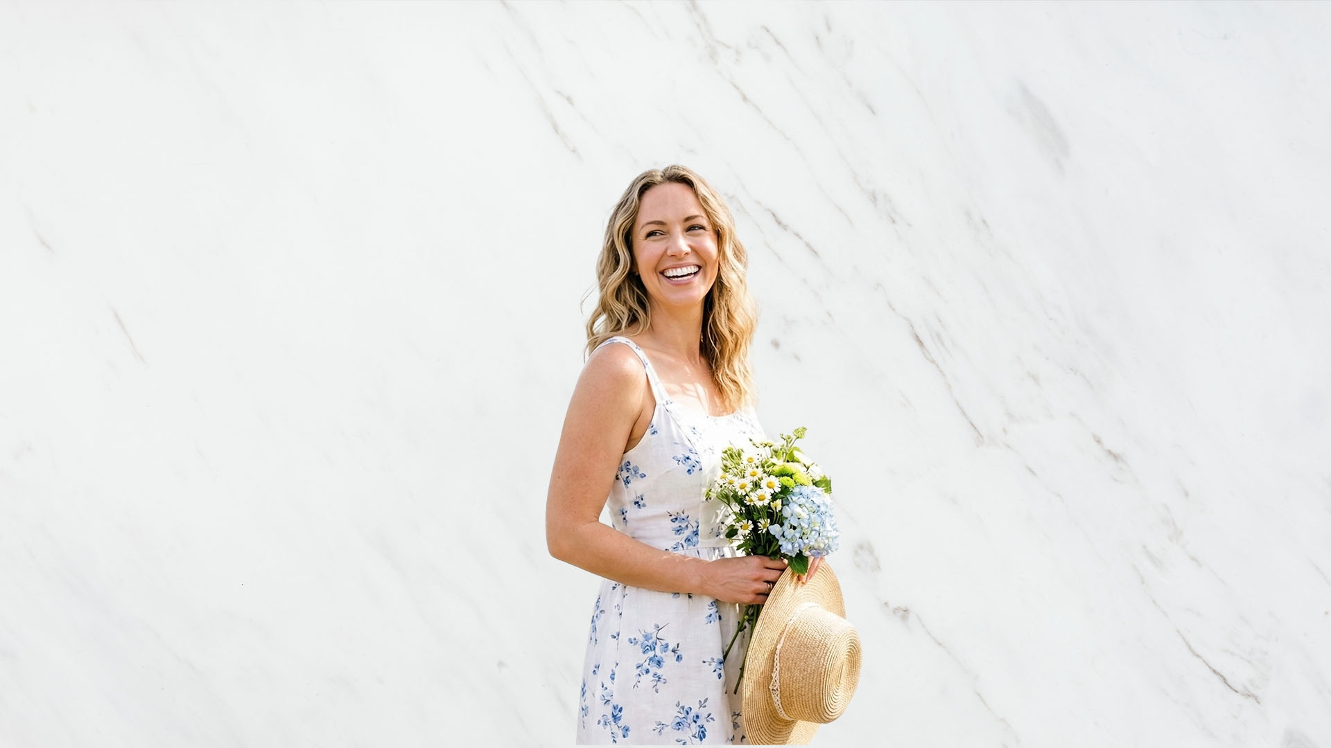 a girl with perfect teeth smiling with flowers in her hands