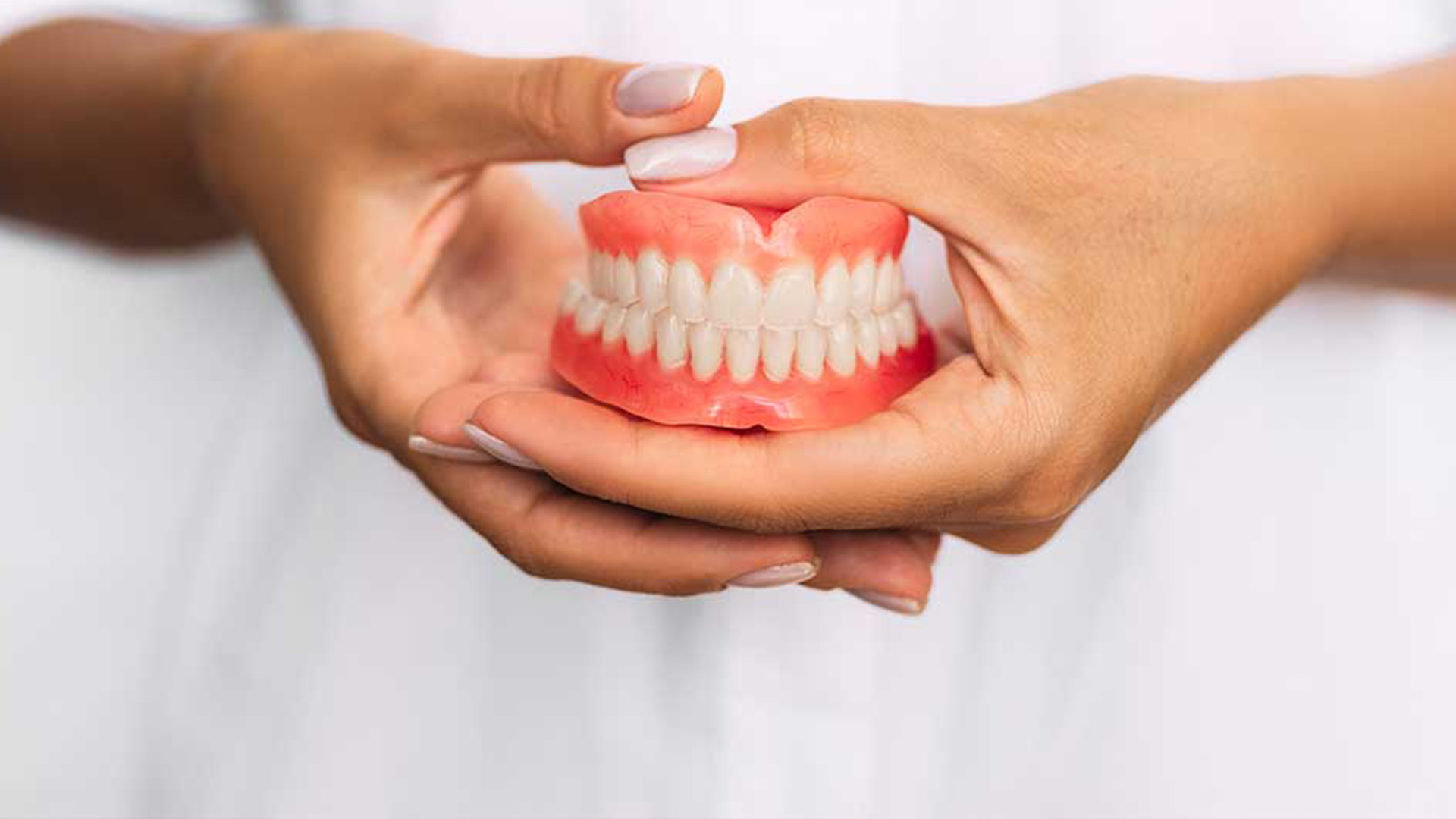 a dentist holding snap on dentures modesto