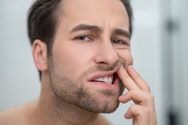 a man with an infected tooth seeking an emergency dentist near me